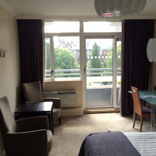 Hotel room with windows and glass door.