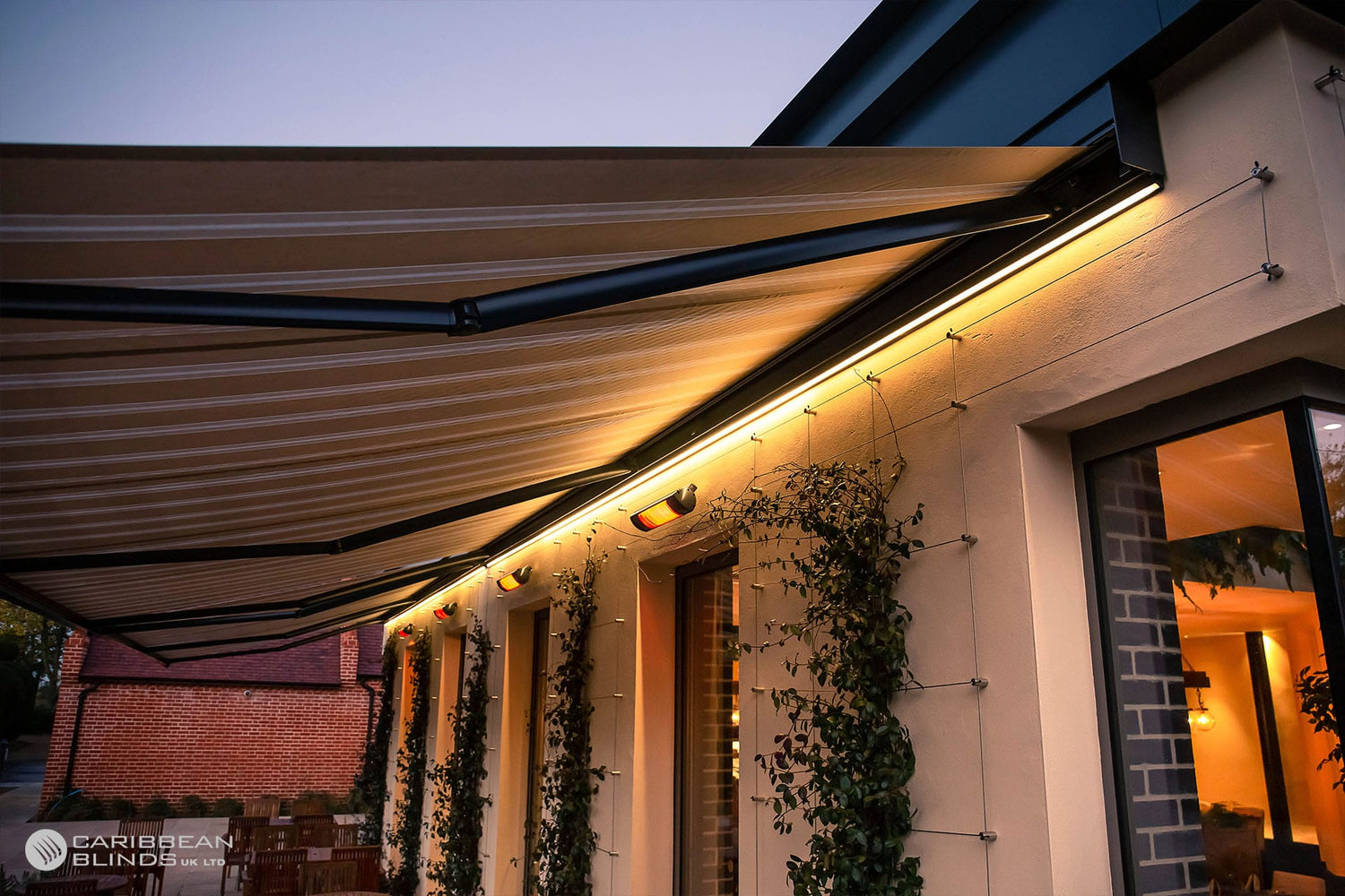 Retractable awning on a house exterior with warm lighting
