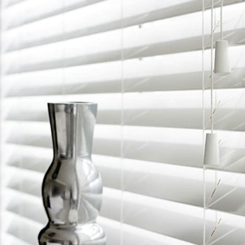 Blinds with empty vase in front