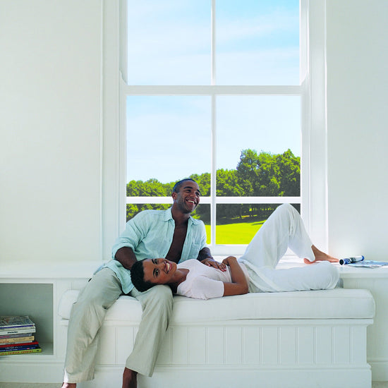 Couple relaxing by a window in a modern sitting room